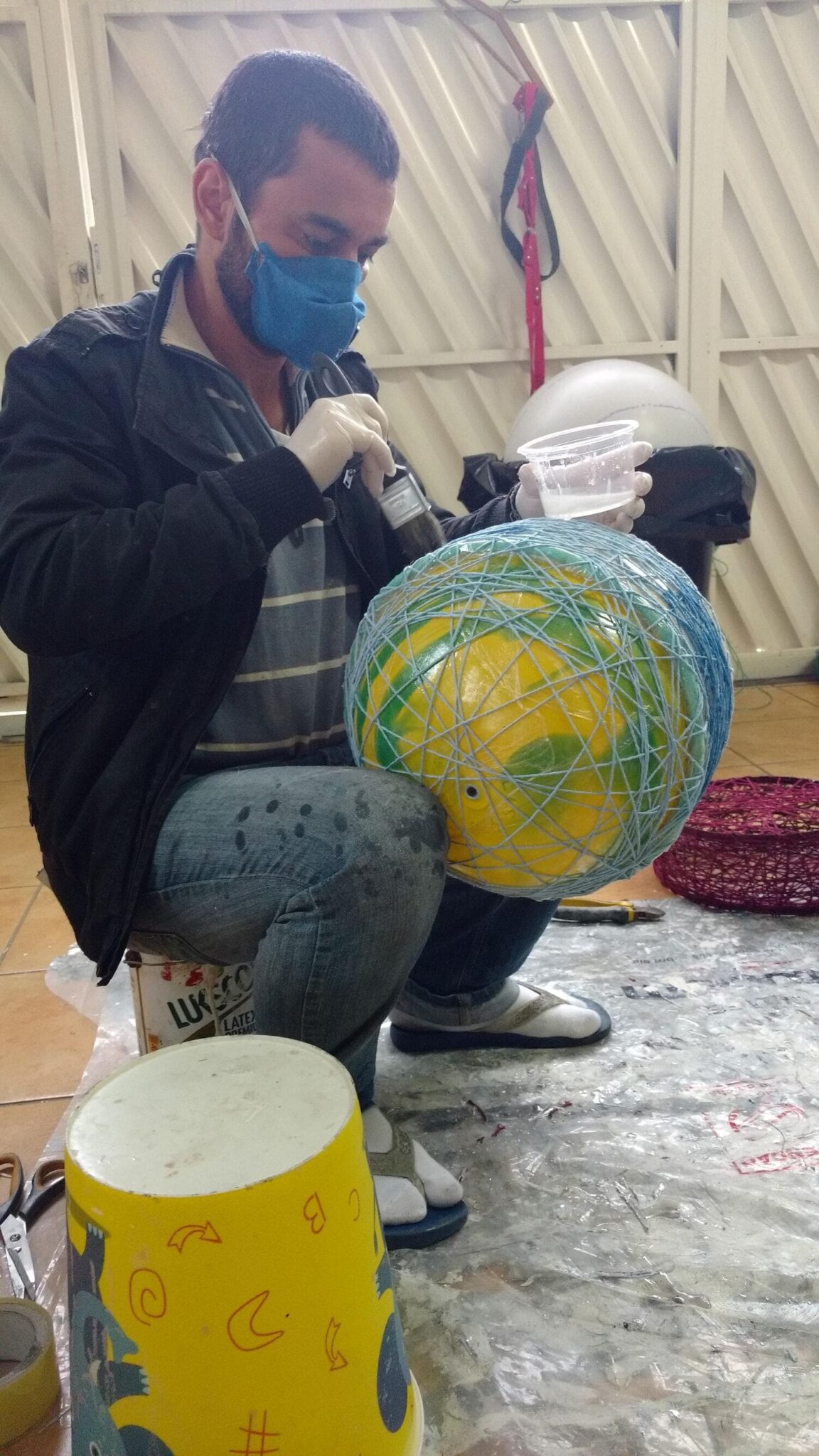 Marcello trabalhando na fabricação artesanal de uma toca sobre o molde.