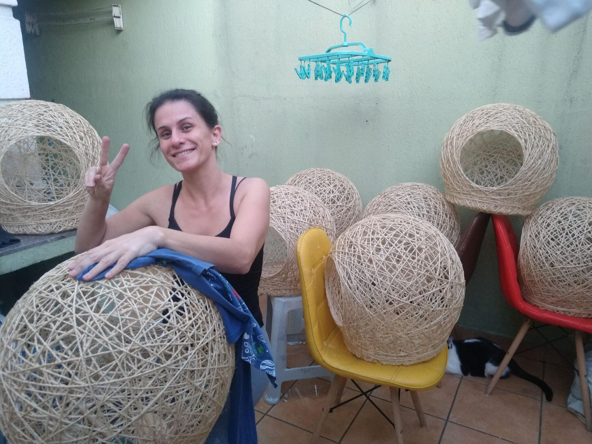 Esposa de Marcello junto a diversas tocas artesanais em produção.